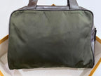 An olive green nylon laptop sleeve with dark brown leather handles, shown from a top-down view resting on a white surface.