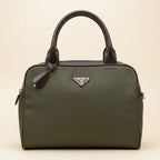 An olive green nylon messenger bag with dark brown leather trim and handles, featuring a silver-tone triangular Prada logo plaque on the front.